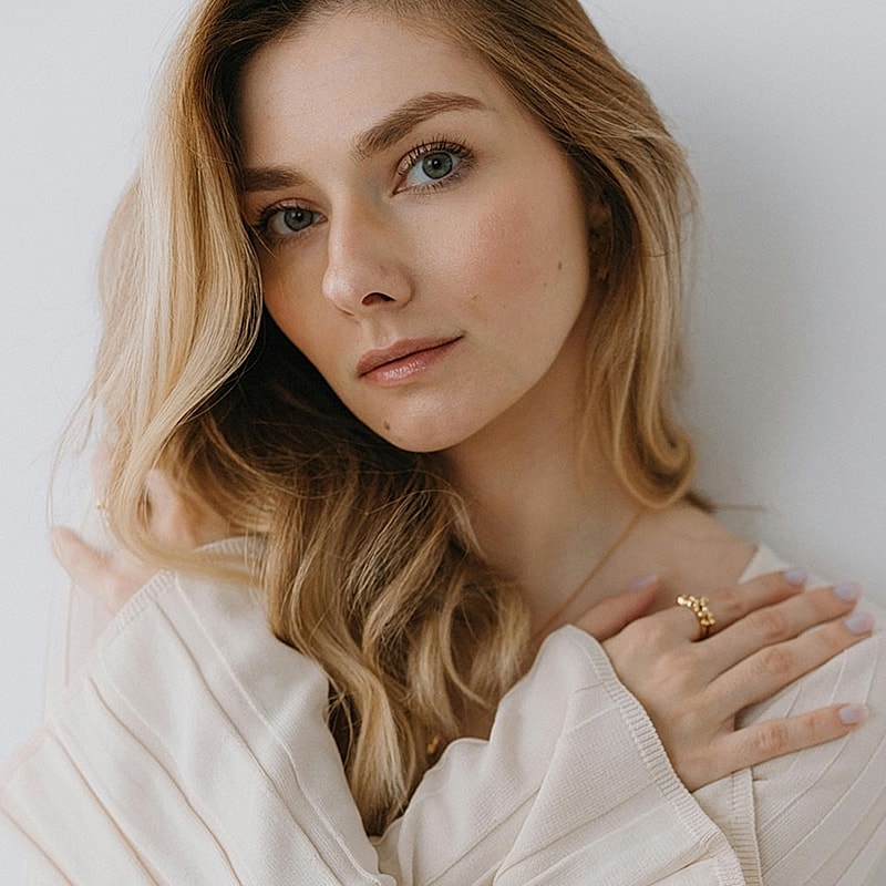 Woman with long hair wearing a stylish top.